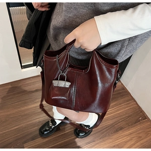 Dettaglio della borsa bordeaux vintage in ecopelle con lucchetto d'argento e cuciture