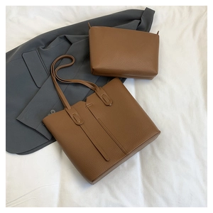 Ensemble de sacs cabas en cuir grainé marron avec pochette sur fond de tissu blanc