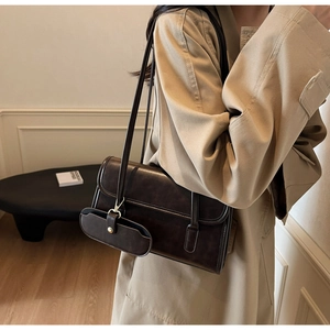 Detail view of large dark brown retro shoulder bag with a matching small coin purse