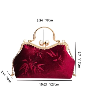Close-up of velvet vintage handbag with bamboo pattern, gold frame and pearl clasp