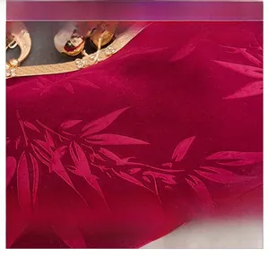 Detail of burgundy velvet clutch with bamboo leaf texture and pearl rhinestone frame