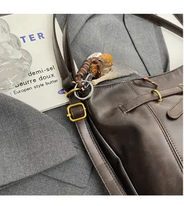 Macro shot of dark brown leather strap with vintage brass buckle and stitching detail
