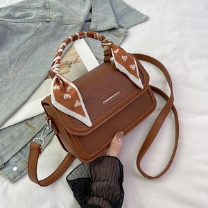 Brown lychee leather crossbody bag with decorative heart pattern silk scarf on handle