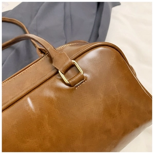 Detail of the high-quality gold hardware and fine stitching on the brown leather bag