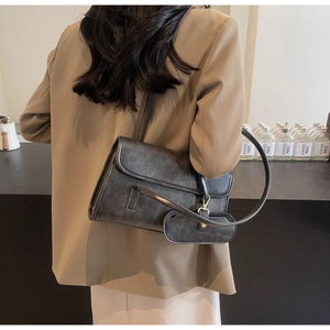 Detail of dark gray vintage leather shoulder bag with matching mini pouch on model