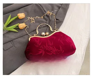 Detail of red velvet evening bag with bamboo texture, pearl clasp and gold handle