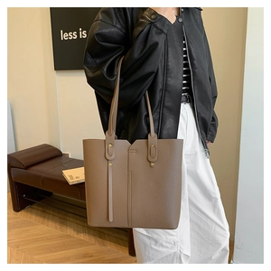 Mannequin portant un grand sac cabas en cuir grainé marron avec bandoulière fine