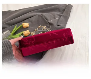 Detailed bottom view of burgundy velvet handbag featuring bamboo jacquard and gold metal rings
