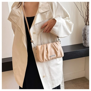 Dettaglio della trama in pelle plissettata e del manico con strass della borsa beige