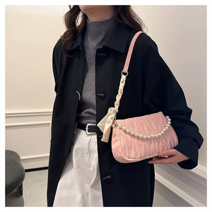 Detail of pink pleated shoulder bag with pearl chain and silk scarf strap on model