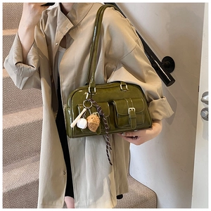 Olive green patent leather Boston bag detail with front flap pockets and baseball charm