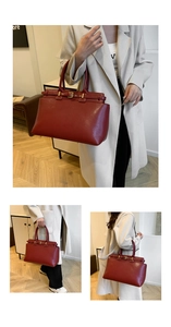Detail view of deep red vintage leather tote bag with decorative strap and metal buckle