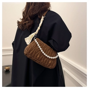 Detail of pleated caramel shoulder bag with large pearl chain and silk wrapped strap