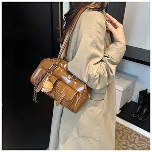 Brown oil wax PU leather Boston bag detail with functional front pockets and charm