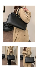 Detailed close-up of large black leather tote bag with gold hardware and smooth texture