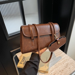 Vintage brown large shoulder bag with mini pouch on a stylish marble background