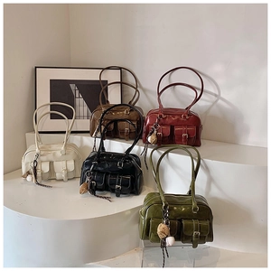 Detail view of five colors of vintage glossy Boston bags on a minimalist white stage