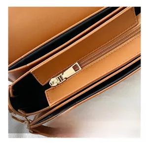 Détail de la fermeture éclair dorée et compartiments internes d'un sac à main marron