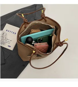 Overhead view showing spacious interior of brown pebbled leather tote bag with striped lining