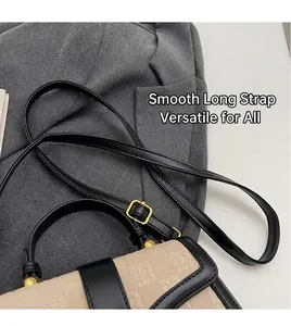 Close-up detail of the adjustable black leather shoulder strap on a small stylish bag