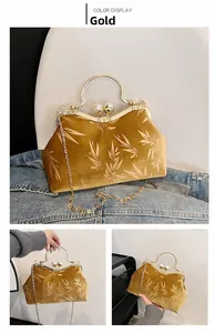 Macro view of gold velvet evening bag with bamboo leaf pattern and pearl clasp detail