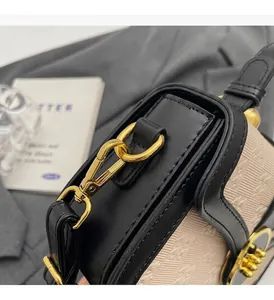 Detail of high-gloss gold hardware and textured embossed pattern on a beige crossbody bag