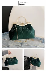 Detail of dark green velvet handbag with bamboo leaf pattern and pearl clasp
