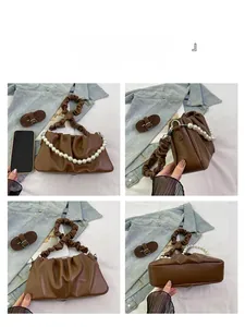 Detail view of brown pleated cloud bag featuring pearl chain and versatile strap options