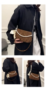 Detail of dark brown pleated shoulder bag featuring pearl chain and cream silk scarf bow