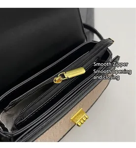 Detail of premium small square crossbody bag showing top zipper and metal buckle