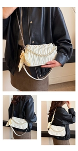 Detail of white quilted handbag with pearl handle and decorative yellow silk scarf