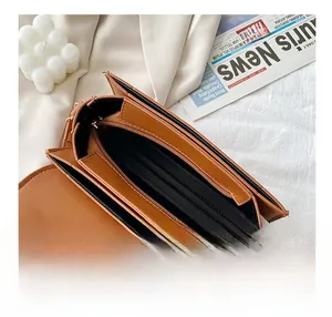 Détail de l'intérieur du sac bandoulière caramel avec compartiments zippés et fentes