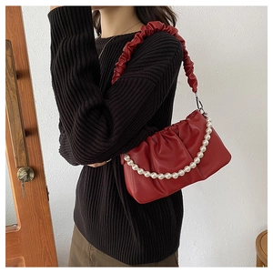 Detailed close-up of a red pleated cloud bag with elegant pearl chain and soft PU texture