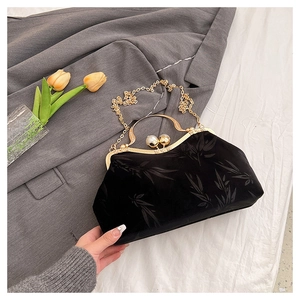 Detail of black velvet evening bag with bamboo leaf pattern and pearl clasp