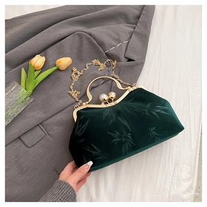 Detail of emerald velvet bag with bamboo pattern, gold handle and pearl clasp