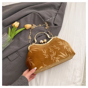 Detail of velvet bag with bamboo leaf print, pearl clasp and gold chain strap