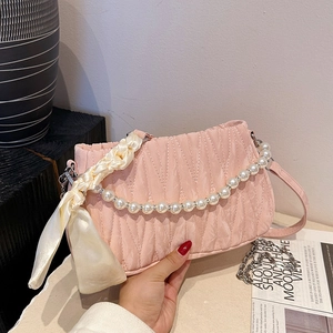 Pale pink pleated shoulder bag with pearl chain handle and decorative silk scarf accessory