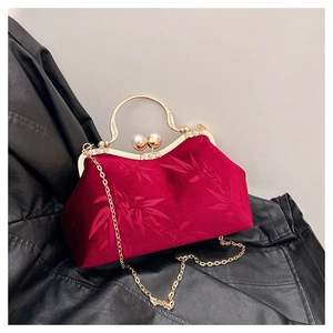 Detail of red velvet handbag with bamboo leaf jacquard and large pearl clasp detail