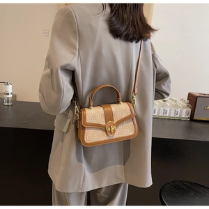 Chic beige textured crossbody bag with brown leather trim and golden clasp details