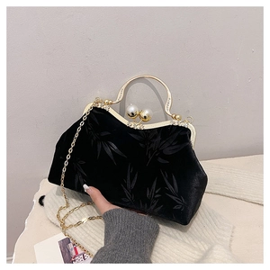 Detail of vintage black velvet handbag with bamboo pattern and pearl metal clasp