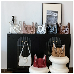 Detailed view of fashionable contrast-color shoulder bags with woven edges and square buckles