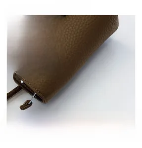 Detail of brown lychee grain leather bucket bag with houndstooth scarf and silver hardware