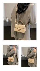 Close-up of beige textured leather crossbody bag with golden hardware and embossed pattern