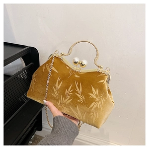 Detail of vintage velvet handbag with bamboo leaf patterns and pearl clasp closure