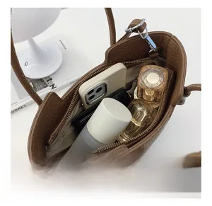 Detail view of brown leather bucket bag interior with compartments and storage capacity