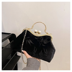 Detail of vintage black velvet clutch featuring bamboo patterns and pearl clasp closure