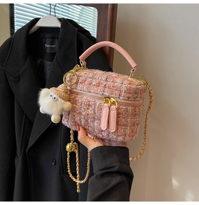 Detailed view of pink tweed mini bag with leather handle and plush charm accessory