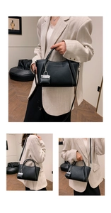Detail of black lychee grain leather tote bag with silver chain mini purse charm