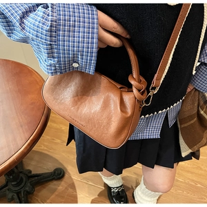 Dettaglio della borsa a nuvola marrone con il logo fashion and bags goffrato sopra