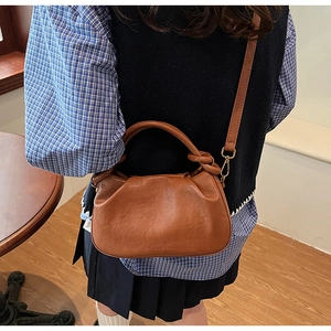 Vista laterale dettagliata di una borsa a nuvola marrone indossata da una modella